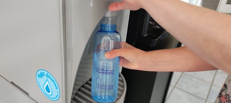 Eine Trinkflasche wird am Wasserspender bei den Stadtwerken Kevelaer gefüllt.