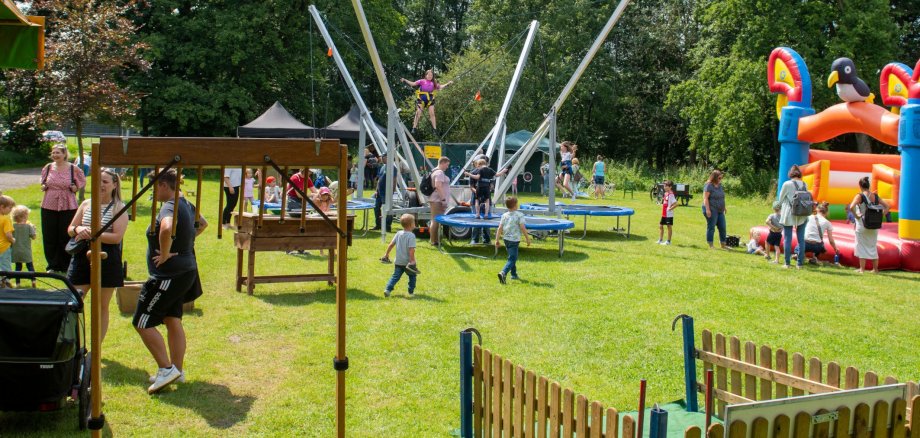 Spielende Kinder auf Hüpfburgen und Trampolinen