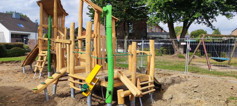 Ein großes Holz-Klettergerüst, dessen Fundamente noch zu sehen sind. 