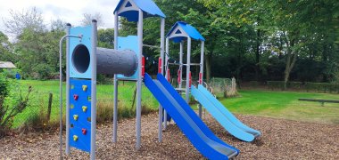 Ein großes blaues Klettergerüst auf einem Spielplatz.